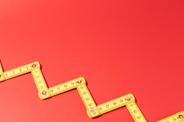 A carpenters ruler on red