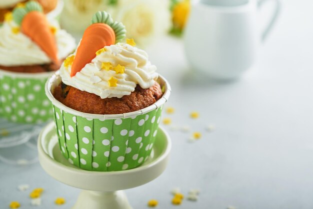 Carrot cake cupcakes for Easter Carrot cupcakes with cream cheese frosting decorated with tiny marzipan carrots on white background Happy Easter and spring holiday concept Holydays homemade dessert