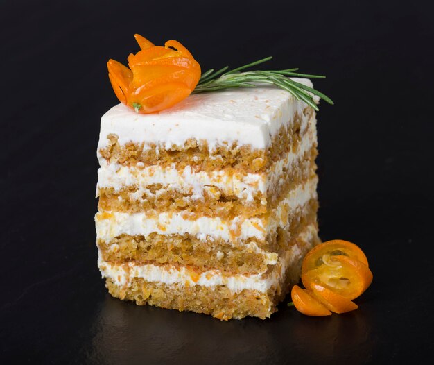 Carrot cake decorated with a branch of rosemary and kumquat 