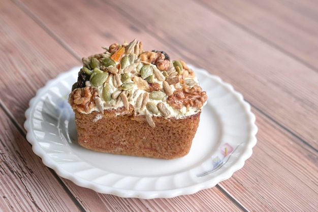 Carrot cake with mixed nuts seeds and dried fruits as topping