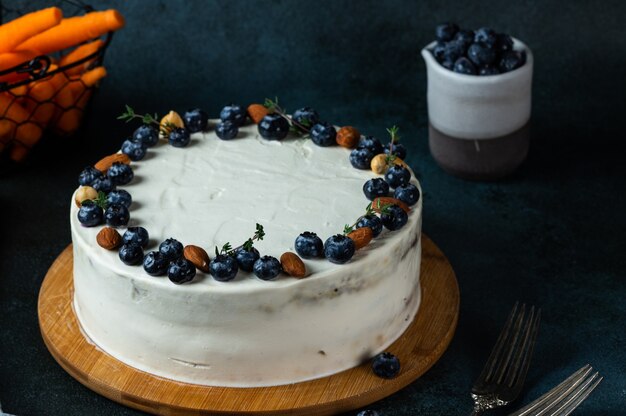 Carrot cake with walnuts and blueberry on dark background. Local food. Traditional american cake. Cake for thanksgiving day. Autumn cake.