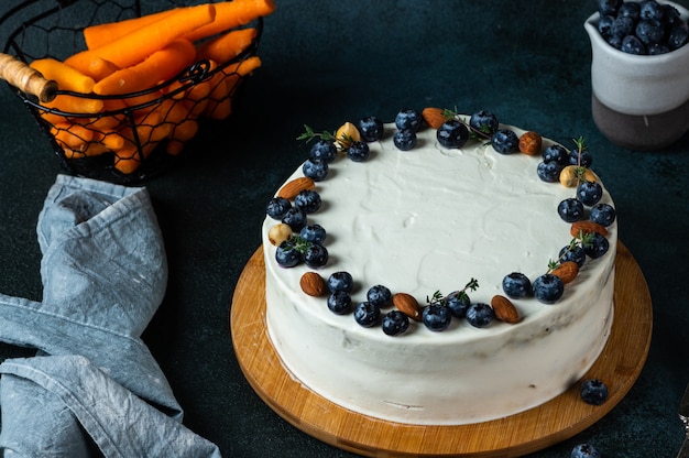 Carrot cake with walnuts and blueberry on dark background. Local food. Traditional american cake. Cake for thanksgiving day. Autumn cake.