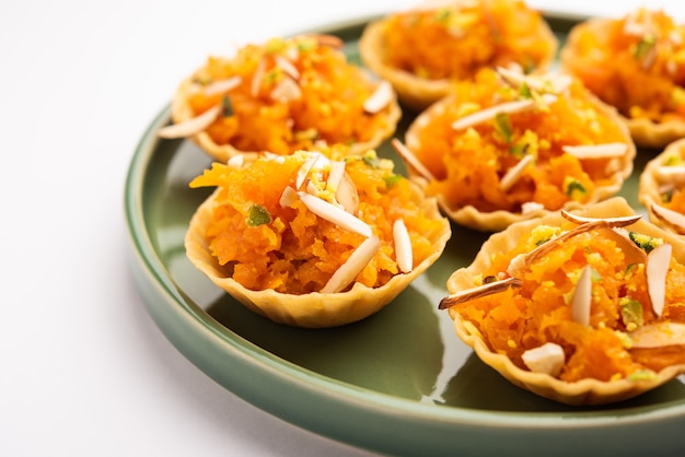 Carrot or Gajar Halwa canape or canapÃÂ© or Fusion Tart, garnished with dry fruits. Indian dessert