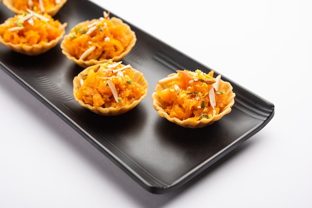 Carrot or Gajar Halwa canape or canapÃÂ© or Fusion Tart, garnished with dry fruits. Indian dessert