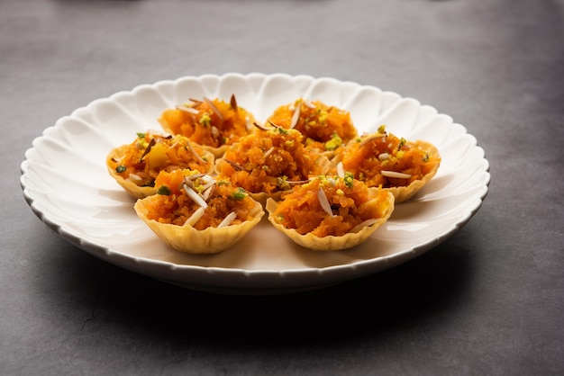 Carrot or Gajar Halwa canape or canapÃÂ© or Fusion Tart, garnished with dry fruits. Indian dessert