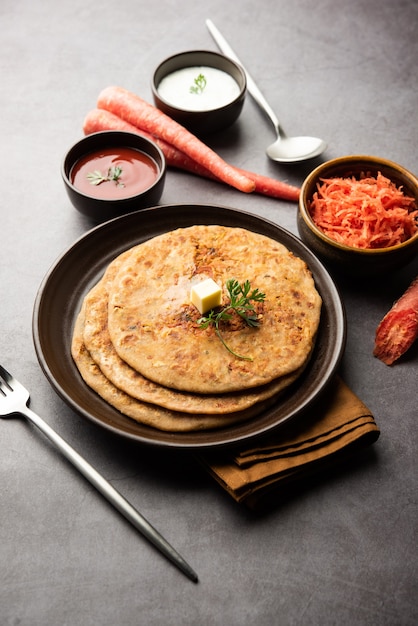 にんじんまたはgajarka parathaは、全粒小麦粉とにんじんで作られたインドの種なしパンであるパンジャブ料理です。ケチャップと豆腐を添えて