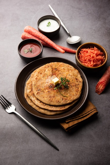 にんじんまたはgajarka parathaは、全粒小麦粉とにんじんで作られたインドの種なしパンであるパンジャブ料理です。ケチャップと豆腐を添えて