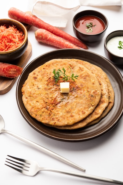 La carota o gajar ka paratha è un piatto del punjabi che è una focaccia indiana non lievitata fatta con farina integrale e carote. servito con ketchup e cagliata