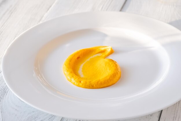 Carrot garlic cream garnish on the white plate