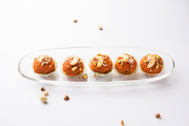 Carrot Halwa Laddu or sweet balls,  served in a plate with dry fruits toppings. selective focus