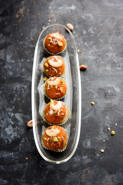 Carrot Halwa Laddu or sweet balls,  served in a plate with dry fruits toppings. selective focus