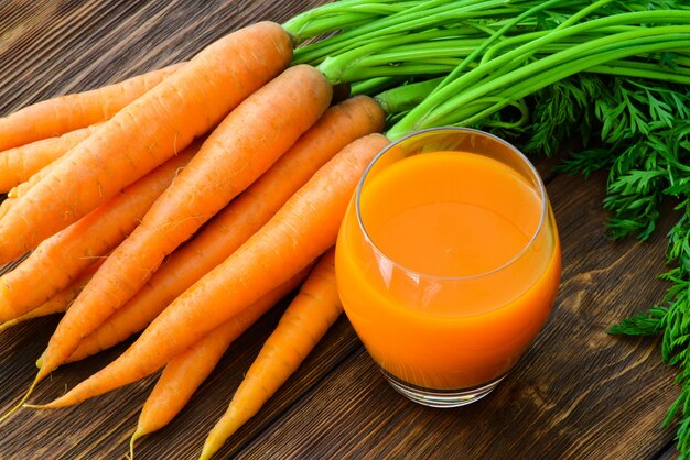 Carrot juice in glass and fresh carrot