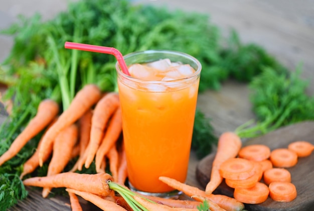 Carrot juice on wooden table background fresh and sweet carrot slices for cooking food fruits and vegetables for health concept fresh carrots juice on glass with ice on summer