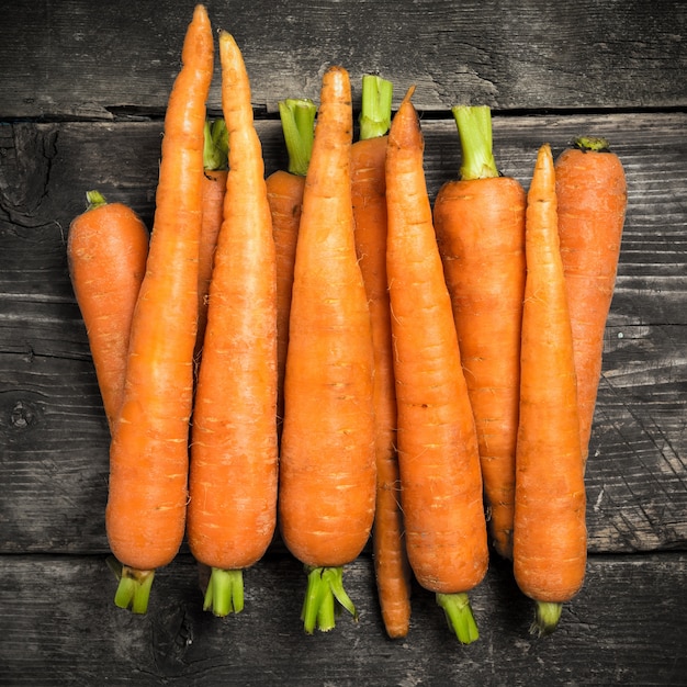 Carota sulle vecchie tavole di legno scure.