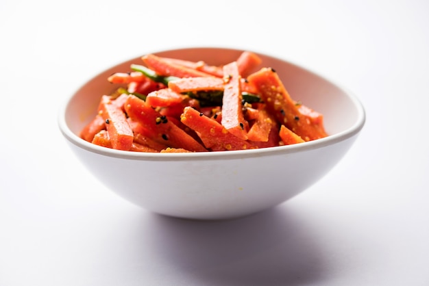 Carrot Pickle or Gajar ka Achar or Loncha in hindi. Served in a bowl over moody background. Selective focus