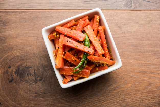 Carrot Pickle or Gajar ka Achar or Loncha in hindi. Served in a bowl over moody background. Selective focus