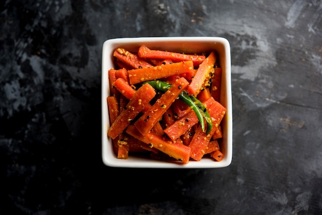 Carrot Pickle or Gajar ka Achar or Loncha in hindi. Served in a bowl over moody background. Selective focus