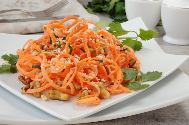 Photo carrot ribbon salad bathed with yoghurt dressing seasoned with fried nuts and sesame seeds