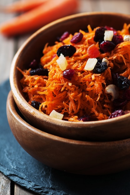 Carrot salad with raisins on the wooden table