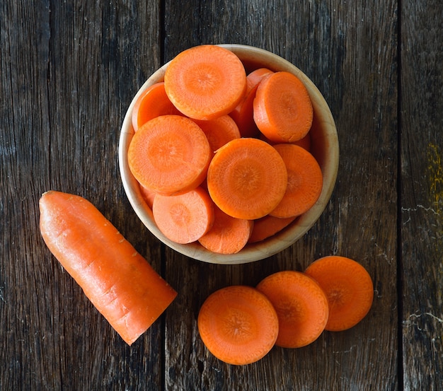 Fette di carota in ciotola di legno