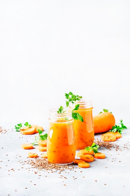 Carrot smoothie or juice with linen seeds healthy and useful drink gray background selective focus