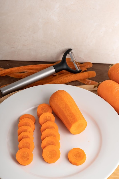 Carrot on a white plate on a wooden board ingredient food preparation