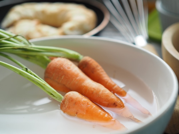 Carrot on wooden table and bright background