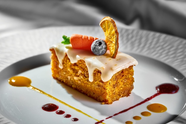 Carrotorange cupcake on a plate with sauces Hard light Carrot cake