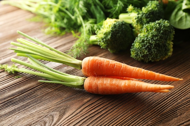 Carrots and broccoli on wooden table