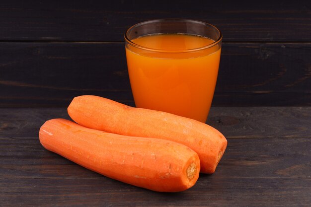 Carrots and juice in a glass black background