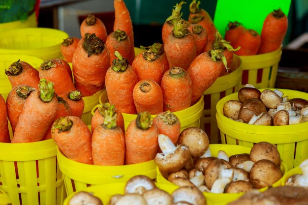 Carrots and mushrooms in containers for sale at market