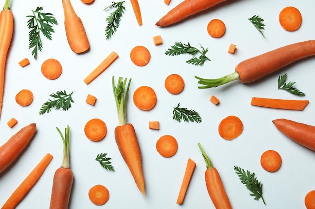 Carrots, slices and leaves of carrot on white background