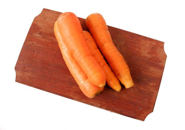 Carrots on a wooden cutting board isolated on a white background