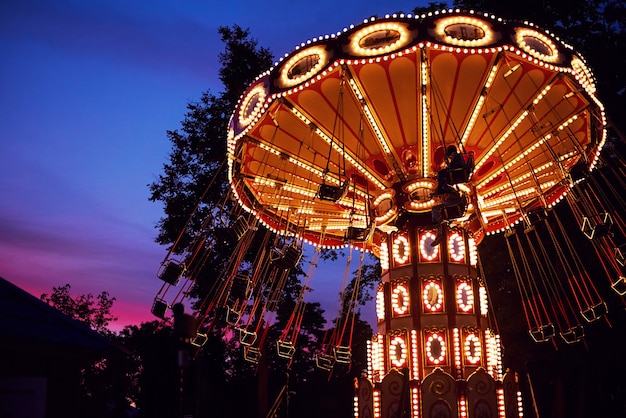 Carrousel draaimolen in pretpark bij avondstad