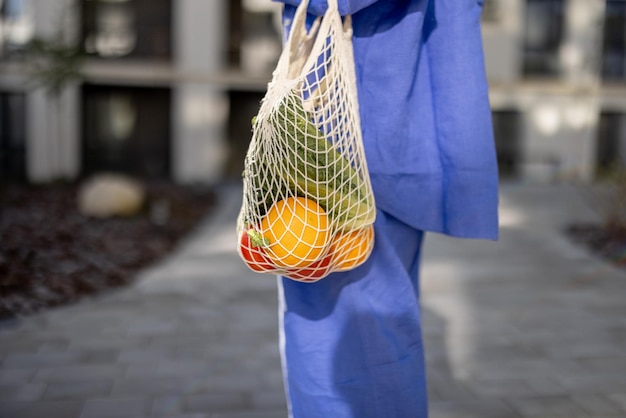 Carrying mesh bag full of fresh fruits and vegetables