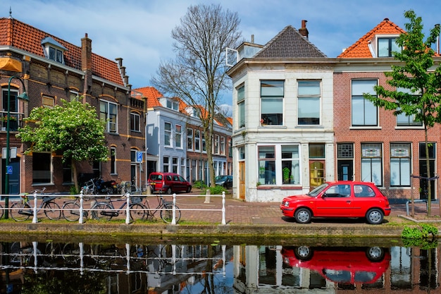 Cars on canal embankment in street of delft delft netherlands