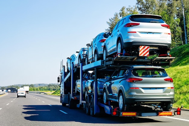 Cars carrier truck on the asphalt road in Poland. Truck transporter