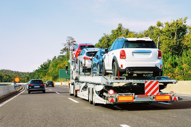 スロベニアのアスファルト道路にある車の運搬トラック。トラックトランスポーター