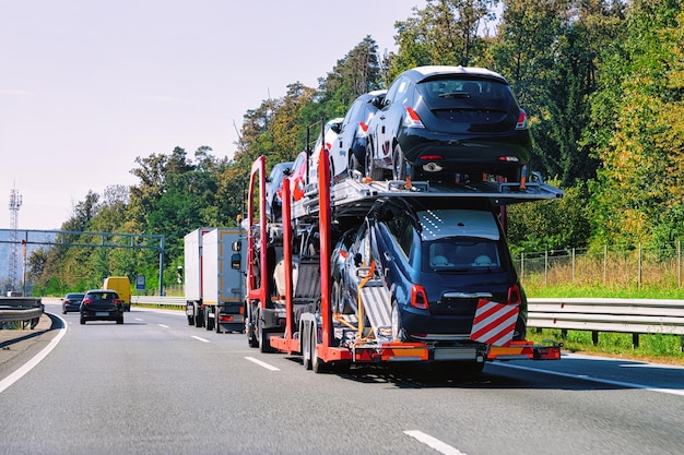 Cars carrier truck on the highway asphalt road in Poland. Truck transporter