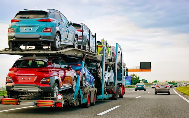 Cars carrier truck in road or highway of Poland. Lorry transporter at logistics work. Trailer with Cargo car drive. Delivery for Transport export industry. Heavy hauler. Haul vehicle. Auto haulage.