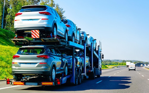 Cars carrier truck in road or highway of Poland. Lorry transporter at logistics work. Trailer with Cargo car drive. Delivery for Transport export industry. Heavy hauler. Haul vehicle. Auto haulage.