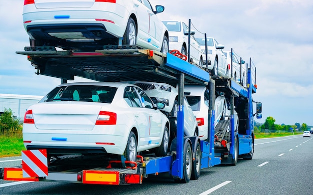 Cars carrier truck in road or highway of Poland. Lorry transporter at logistics work. Trailer with Cargo car drive. Delivery for Transport export industry. Heavy hauler. Haul vehicle. Auto haulage.