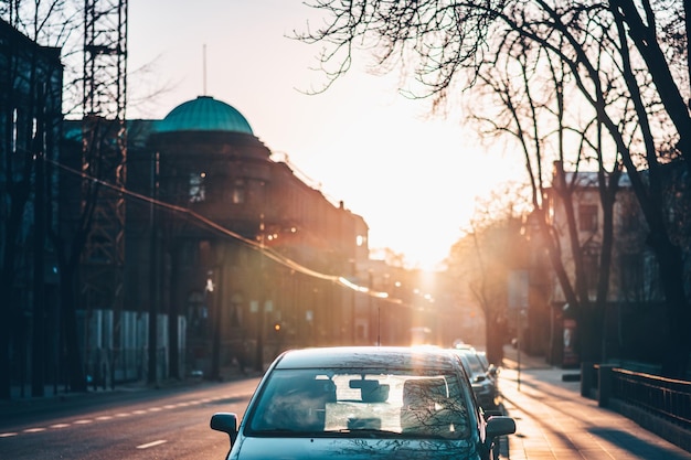 Photo cars on city street against sky during sunset