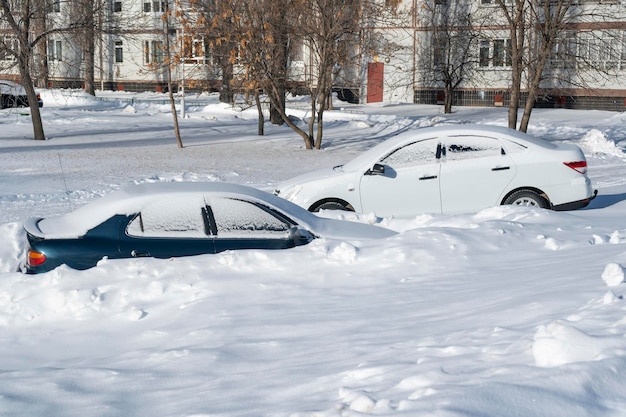 Cars in the courtyard after a blizzard. Winter in Russia