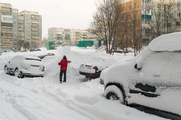 Машины засыпаны снегом после зимней метели