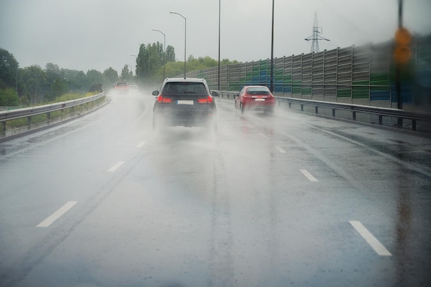 道路を走る車 激しい雨 視界が低い 滑りやすい通り 危険な嵐 り