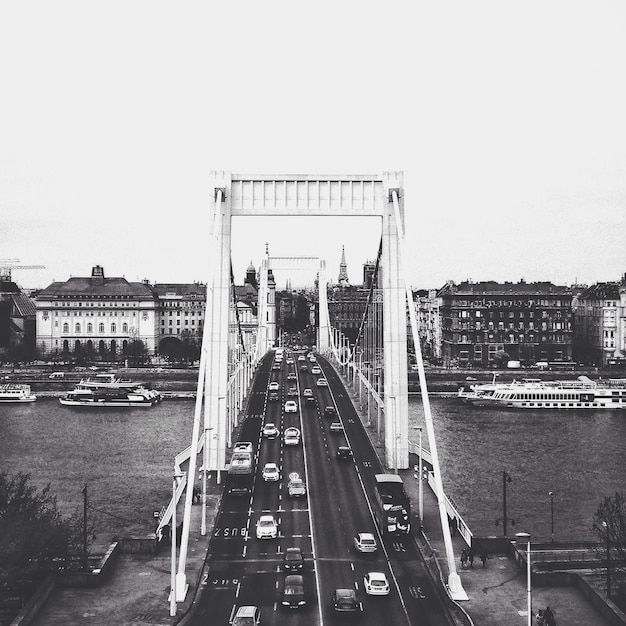 Photo cars moving on bridge over river in city