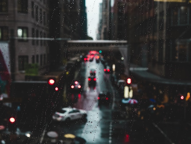 Фото Автомобили на городской улице, видные через мокрое стеклянное окно