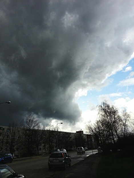 写真 雲の空に逆らって道路を走る車