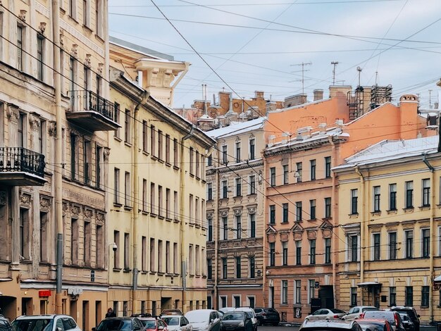 Фото Автомобили на дороге рядом с зданиями в городе напротив неба